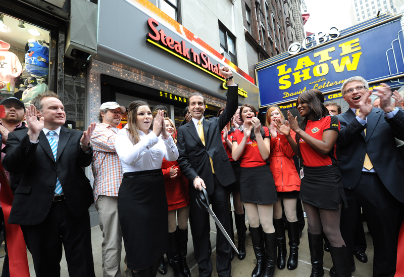 Sardar Biglari, center, in front of New York City’s first Steak ‘n Shake, in 2012. Image via AP